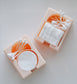 The Hello Cutters Rectangle Cotton Holder Duo features two peach containers: one for round cotton pads, the other for square ones, each topped with neatly arranged Q-tips. Their minimalist design stands out against a white backdrop—ideal for 3D print fans.