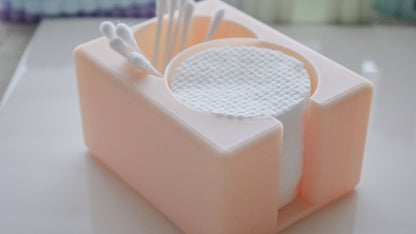 A close-up of the Hello Cutters Round Cotton Holder Duo, holding round cotton pads and Q-tips, arranged neatly on a white surface.