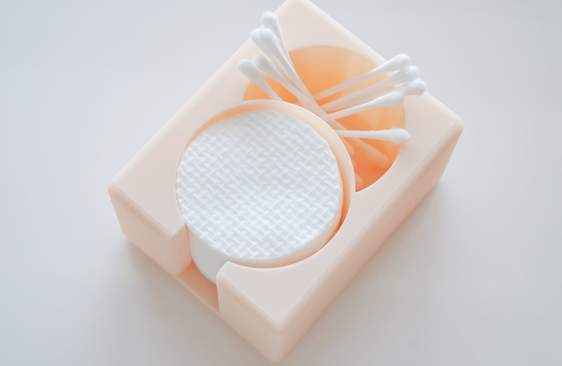The Hello Cutters Round Cotton Holder Duo in beige neatly organizes white cotton pads and Q-tips against a light backdrop.