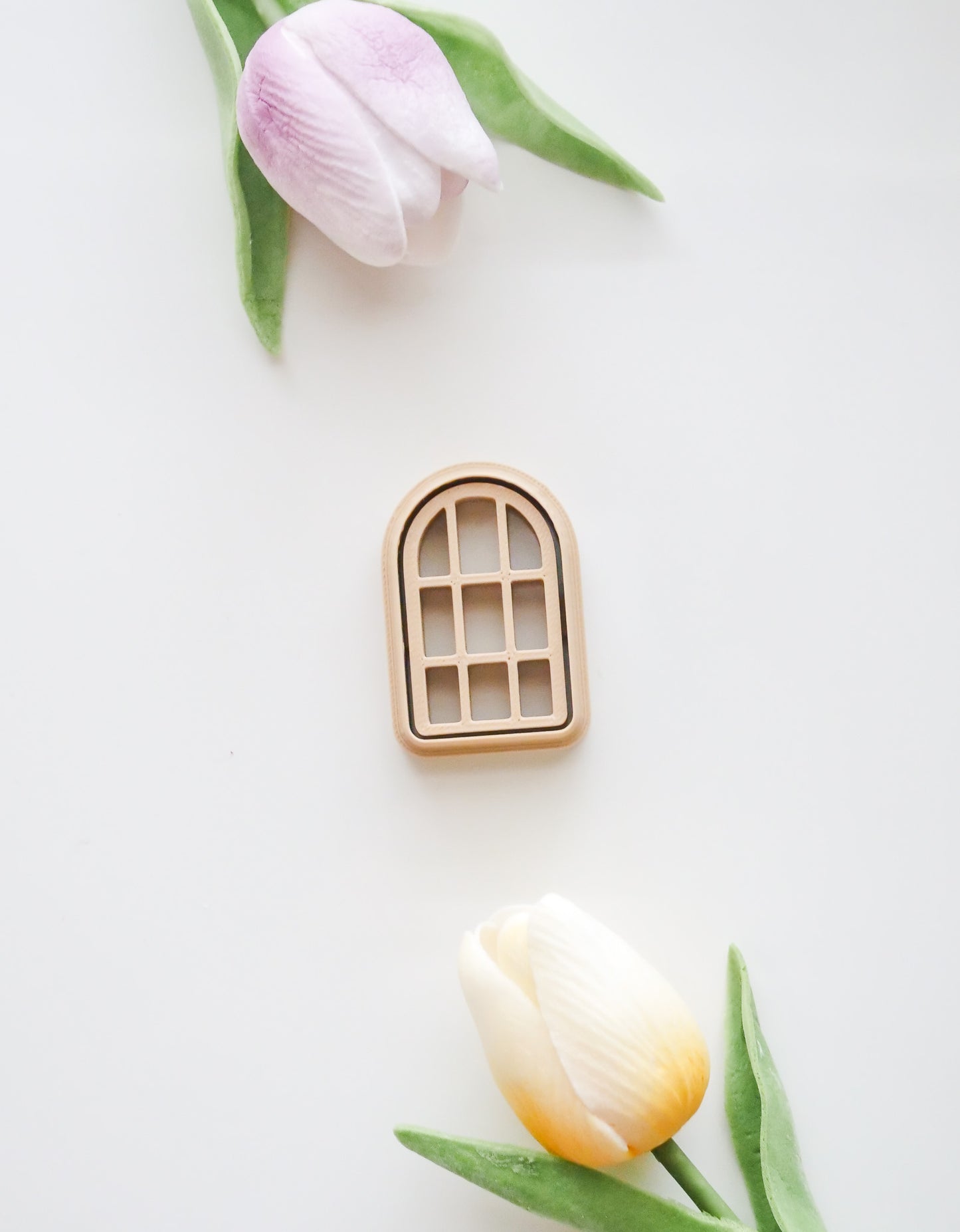 The Window Polymer Clay Cutter Set by Hello Cutters features a small arched window design with a purple tulip on top and a yellow tulip below, both accented with green leaves—ideal as a 3D printable STL file for polymer clay projects.